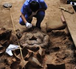 Excavating a terracotta warrior blackened from having been burned in antiquity