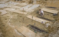 Forrest Follet from the Cobb Institute of Archaeology, Mississippi State University, removes the soil from the lids of 66 unmarked graves uncovered during construction on the UMMC campus in 2013. Photo courtesy UMMC via The Clarion-Ledger.