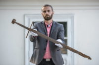 Museum director Bartłomiej Bartecki holding the 14th century sword found in Mircze. Photo by Wojciech Pacewicz/PAP.