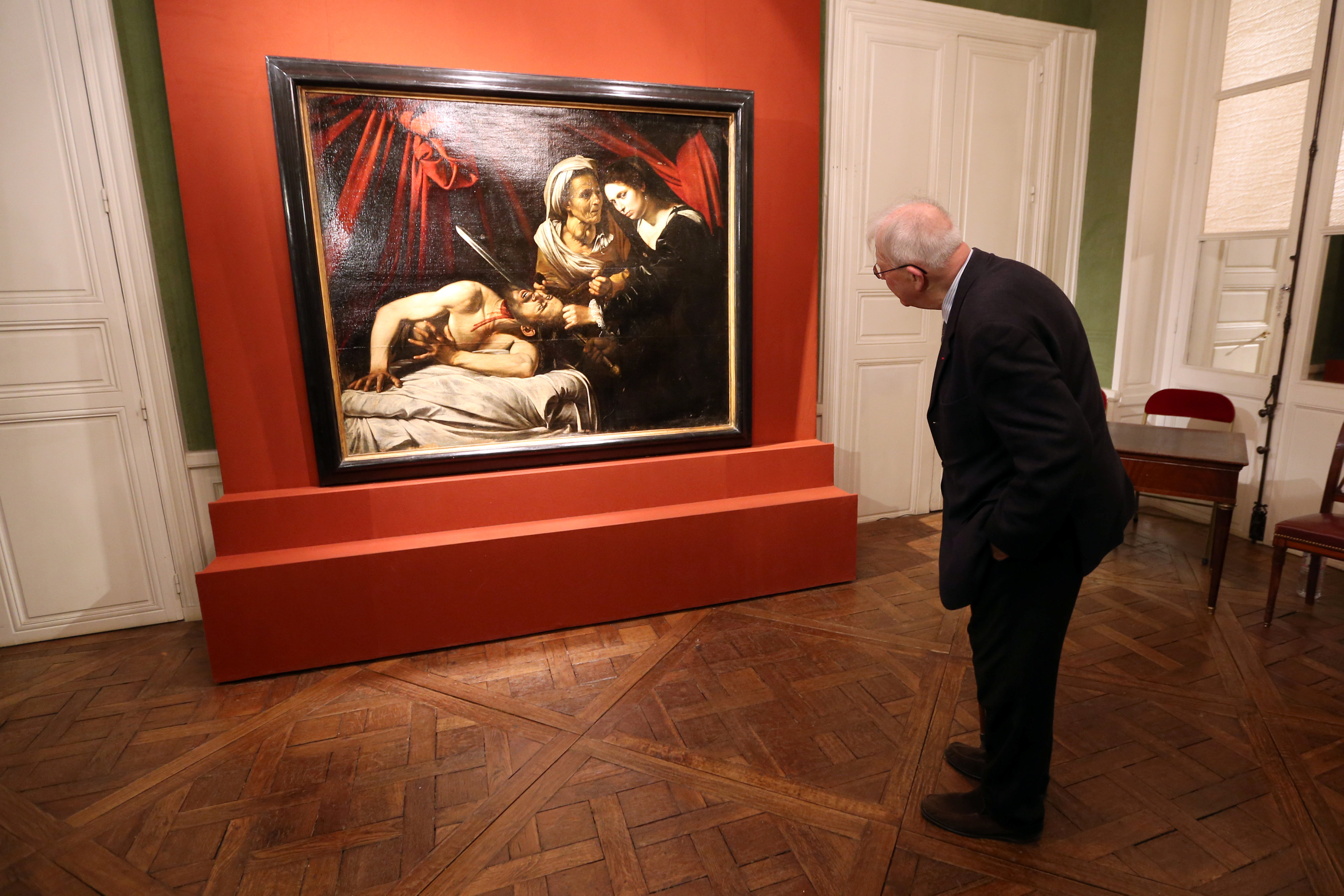 Человек рассматривает картину. Картина на стене в музее. Люди рассматривают картины в музее. Посетитель музея.